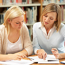 A coach from Your One Degree discusses a workbook exercise with a participant.